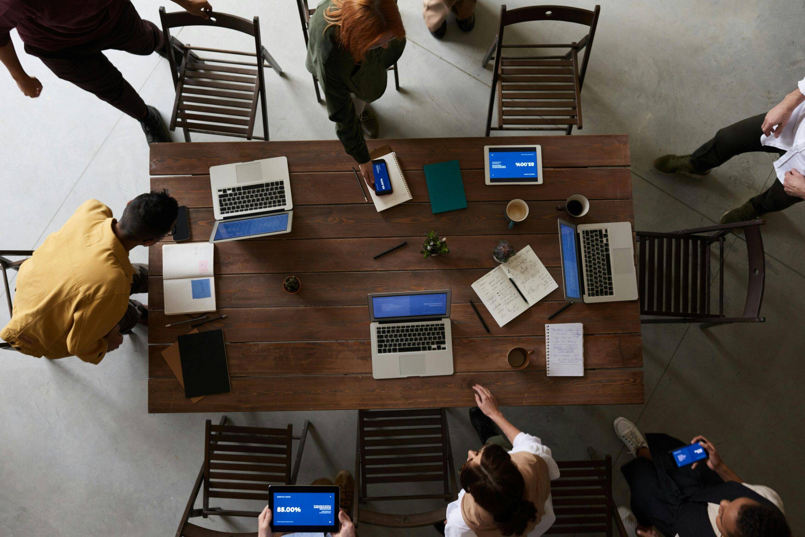 Tech Recruiter Hub: A collaborative meeting space with tech tools, laptops, and notepads used for recruitment strategies in 2024.