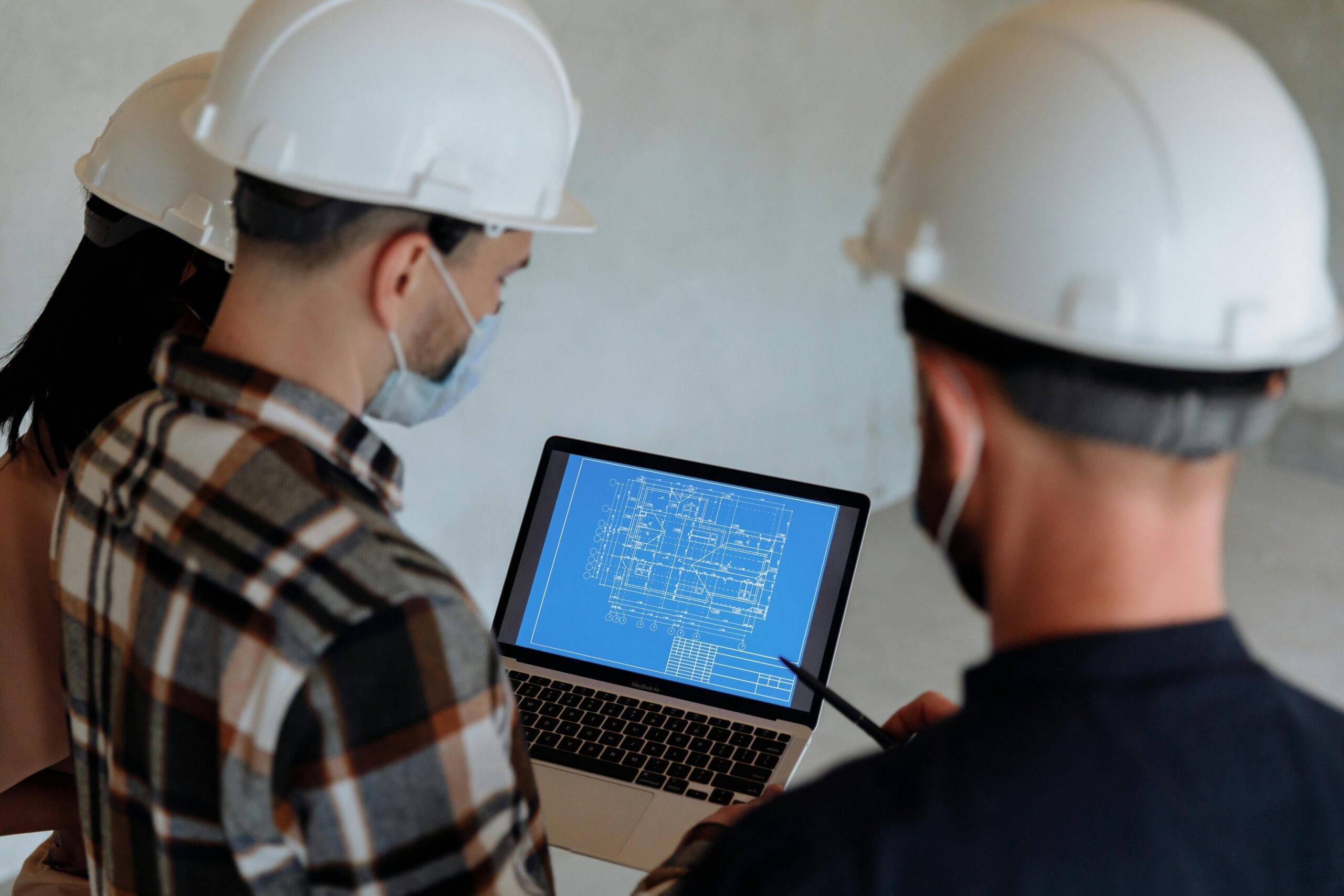 Engineers examining business blueprints AI advantages on a laptop.