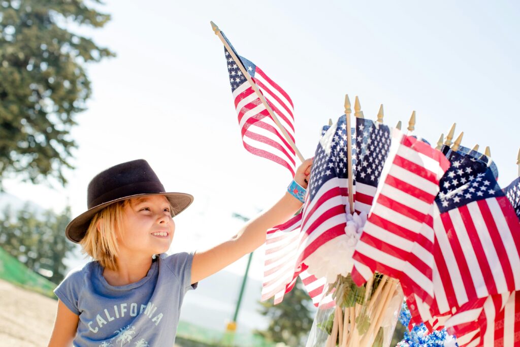 Child holding Trump Vance Flag symbolizing patriotism and support.