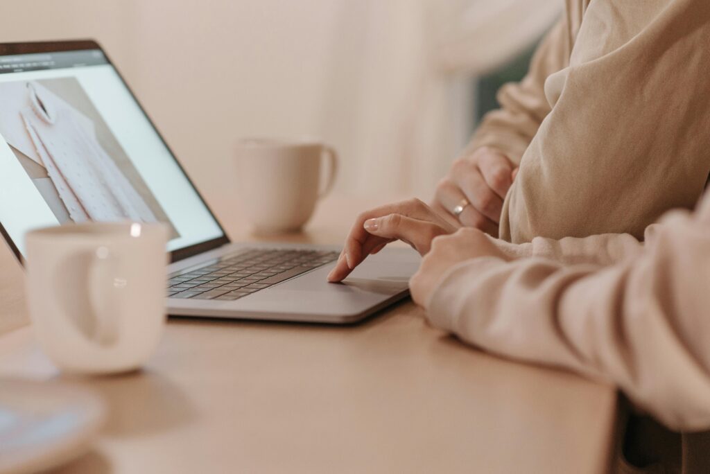 Women Wearing Tech Fleece Sweater Typing on a Laptop