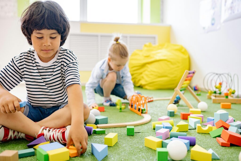 Children engaging with educational toys, promoting motor skills and cognitive development through hands-on activities with a Busy Board in Australia.